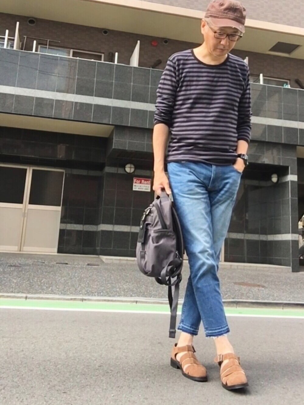 グレー系のニット/セーター、ブルー系のデニムパンツ、ブラウン系のサンダルを着用したメンズの夏コーディネートの1枚目の写真