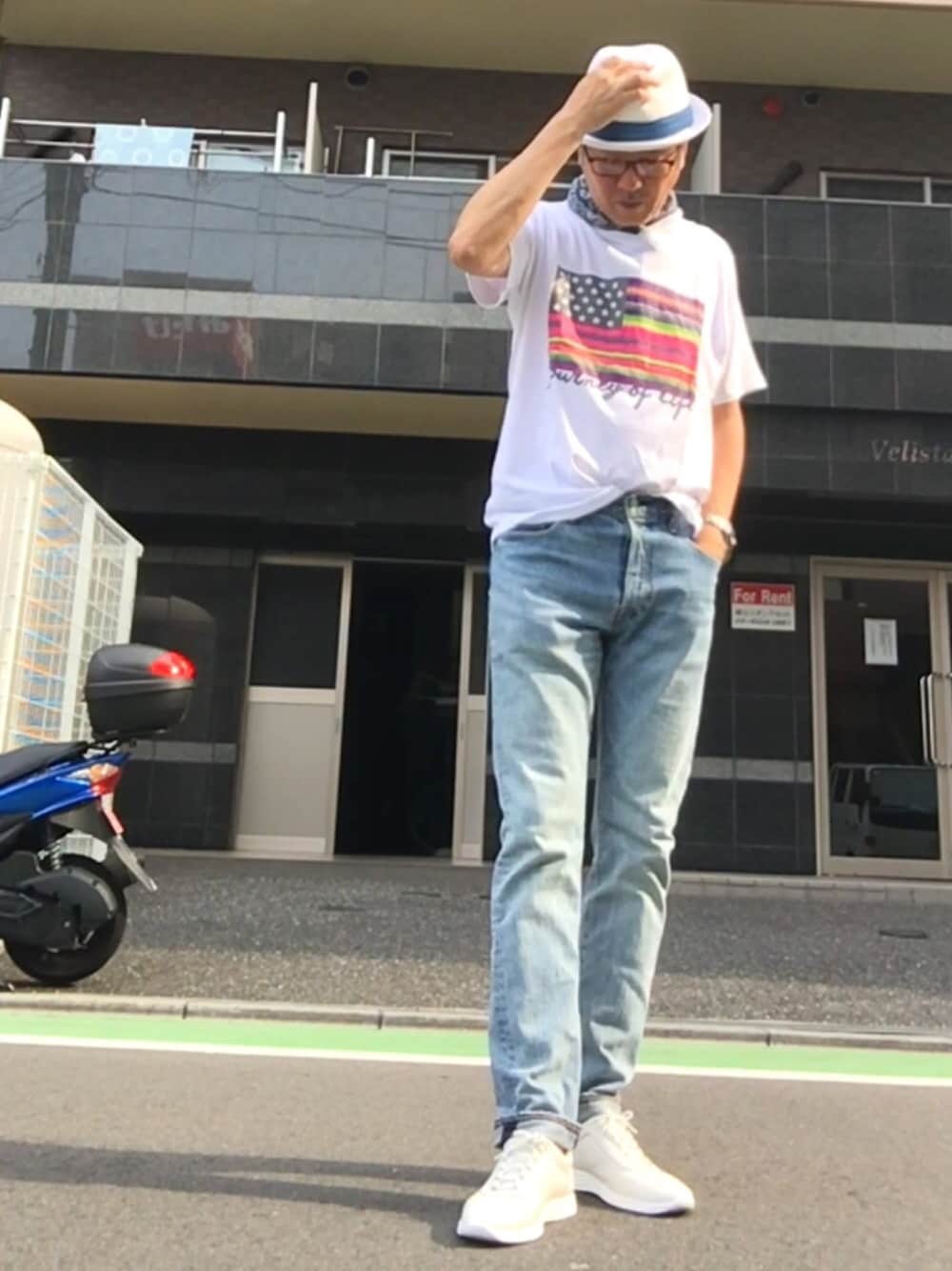 ホワイト系のTシャツ/カットソー、ブルー系のデニムパンツ、ホワイト系のスニーカーを着用したメンズの夏コーディネートの1枚目の写真
