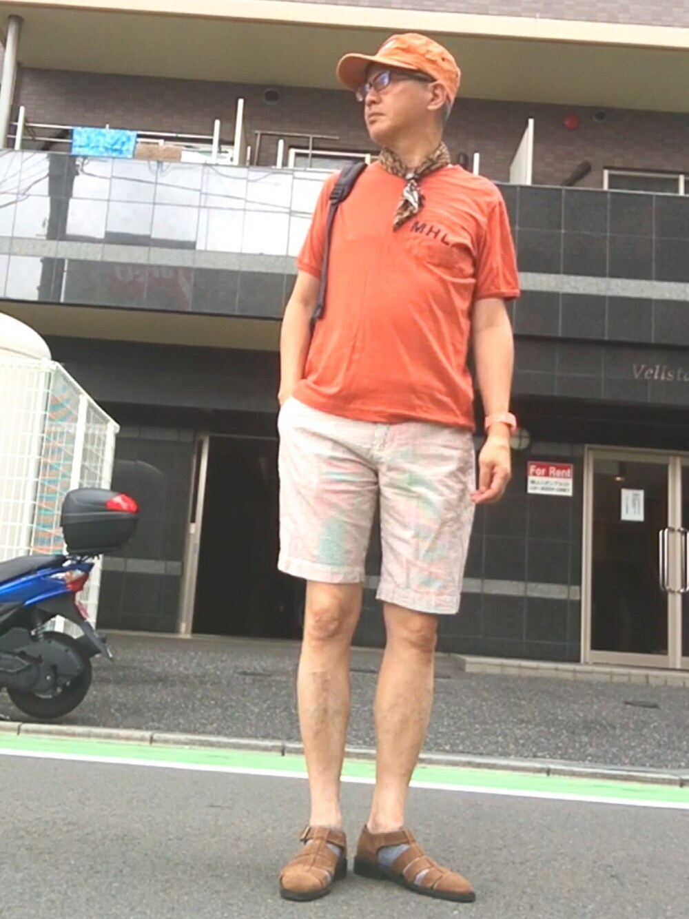 オレンジ系のTシャツ/カットソー、ベージュ系のその他パンツ、ブラウン系のサンダルを着用したメンズの夏コーディネートの1枚目の写真
