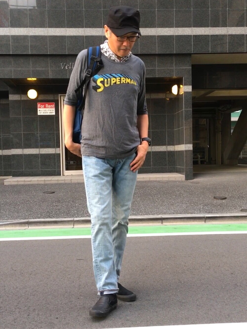 グレー系のTシャツ/カットソー、ブルー系のデニムパンツ、ブラック系のスニーカーを着用したメンズの秋コーディネートの1枚目の写真