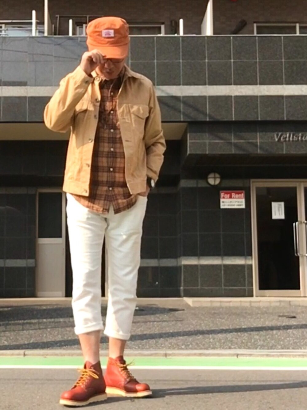 ホワイト系のスラックス、ブラウン系のブーツ、ベージュ系のデニムジャケットを着用したメンズの秋コーディネートの1枚目の写真