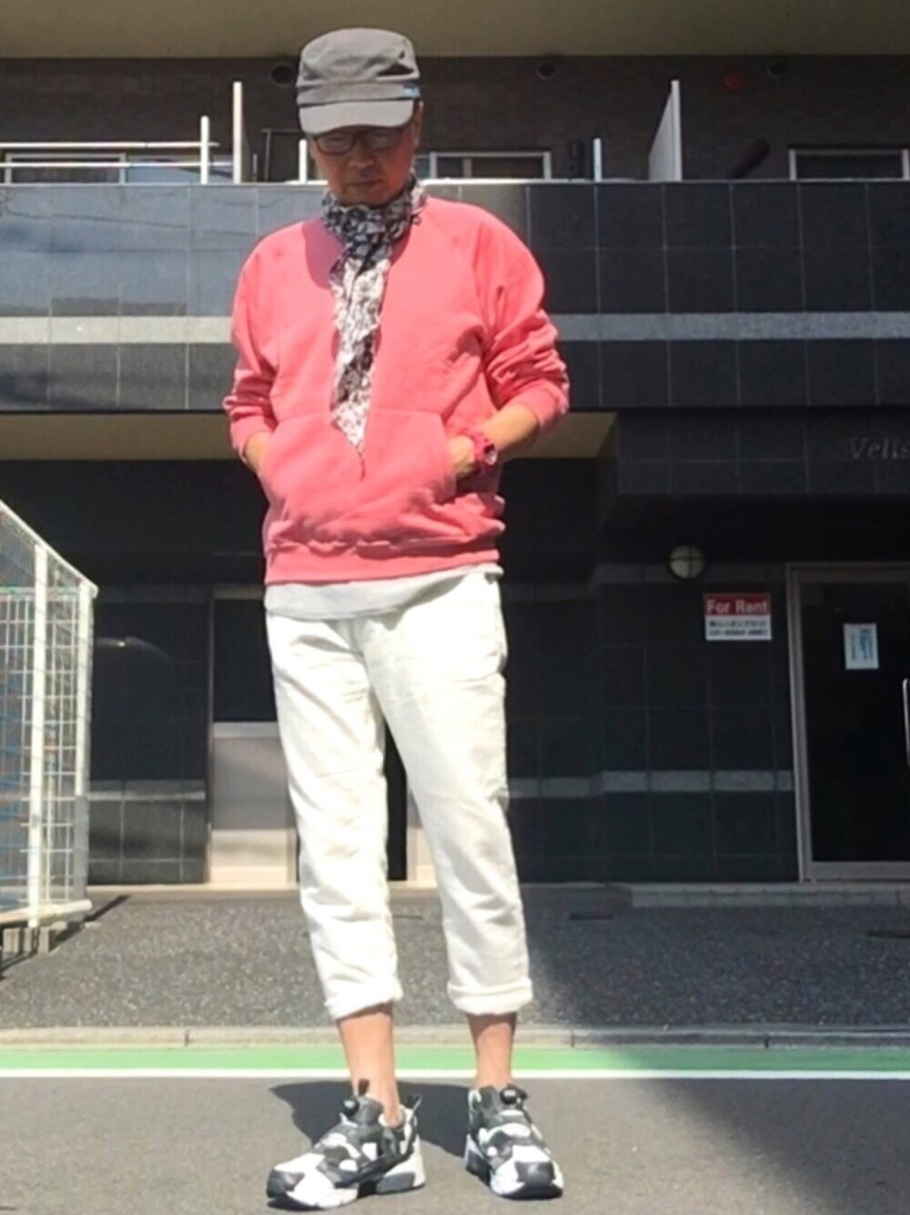 ピンク系のスウェット、ホワイト系のスラックス、ホワイト系のスニーカーを着用したメンズの秋コーディネートの1枚目の写真