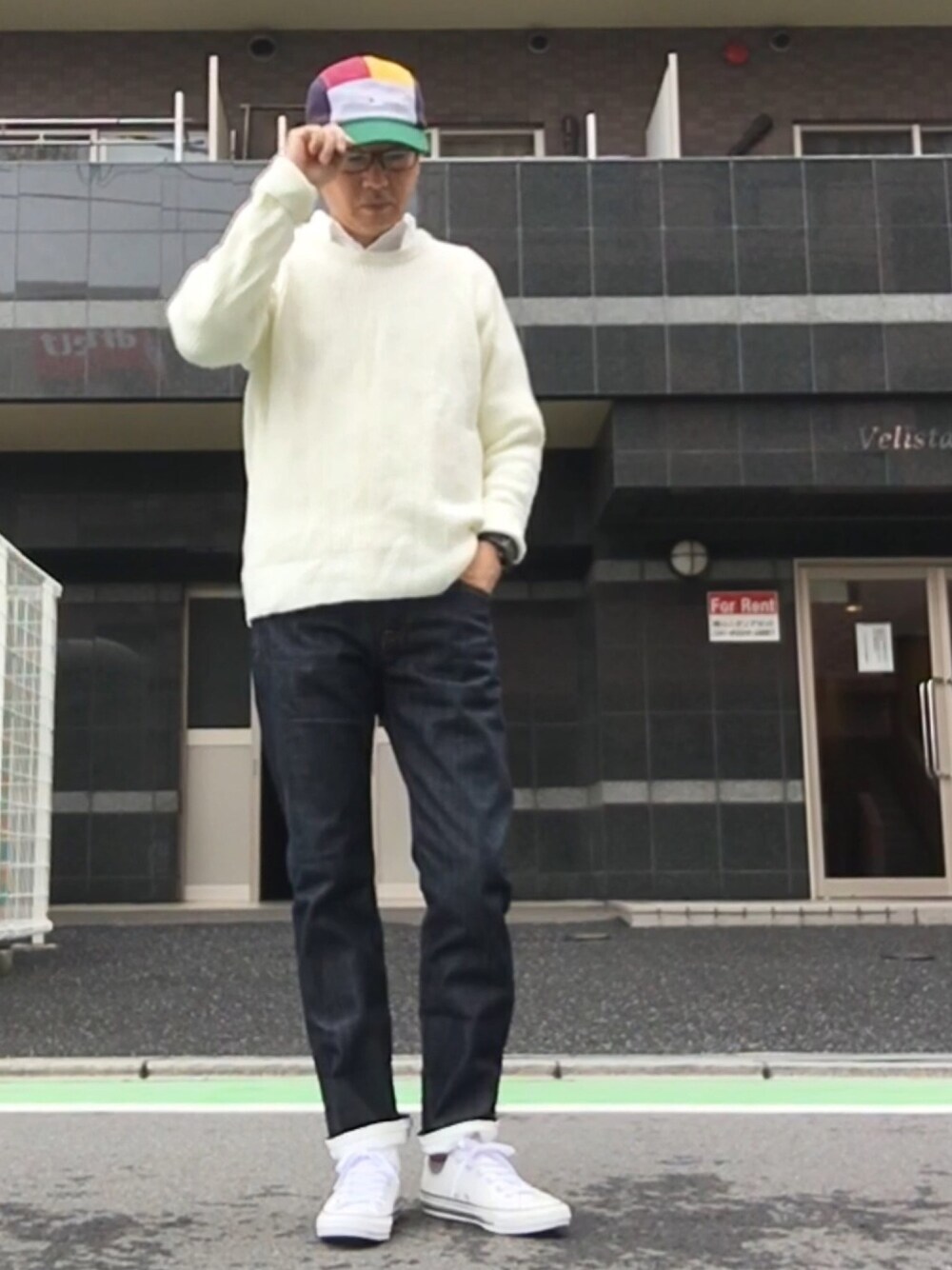 ブルー系のデニムパンツ、ホワイト系のスニーカー、ホワイト系のニット/セーターを着用したメンズの秋コーディネートの1枚目の写真