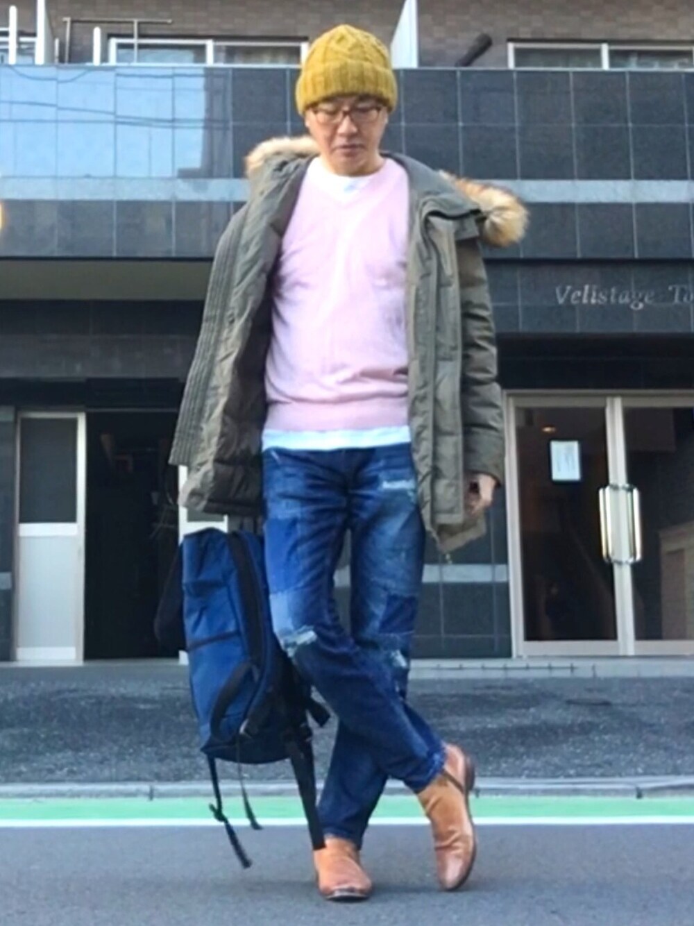 グリーン系のミリタリージャケット、ピンク系のニット/セーター、ホワイト系のTシャツ/カットソーを着用したメンズの冬コーディネートの1枚目の写真