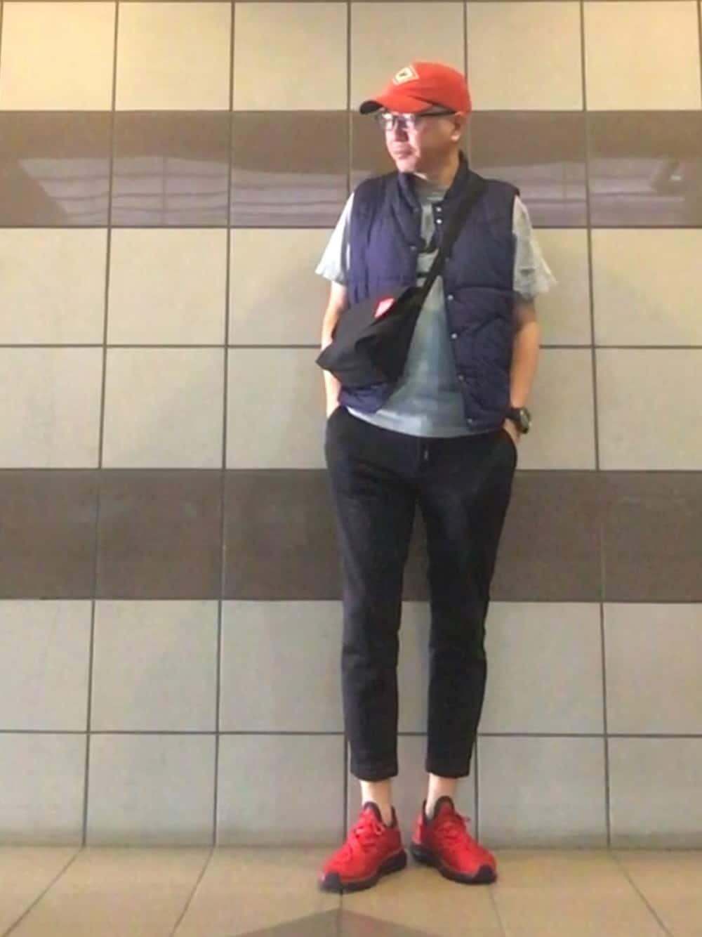 グレー系のTシャツ/カットソー、ブルー系のダウンベスト、グレー系のパンツを着用したメンズの秋コーディネートの1枚目の写真