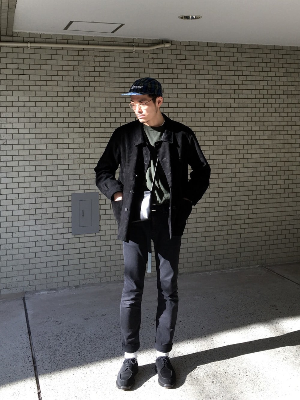 ブラック系のブルゾン、グリーン系のTシャツ/カットソー、ブラック系のデニムパンツを着用したメンズの冬コーディネートの1枚目の写真