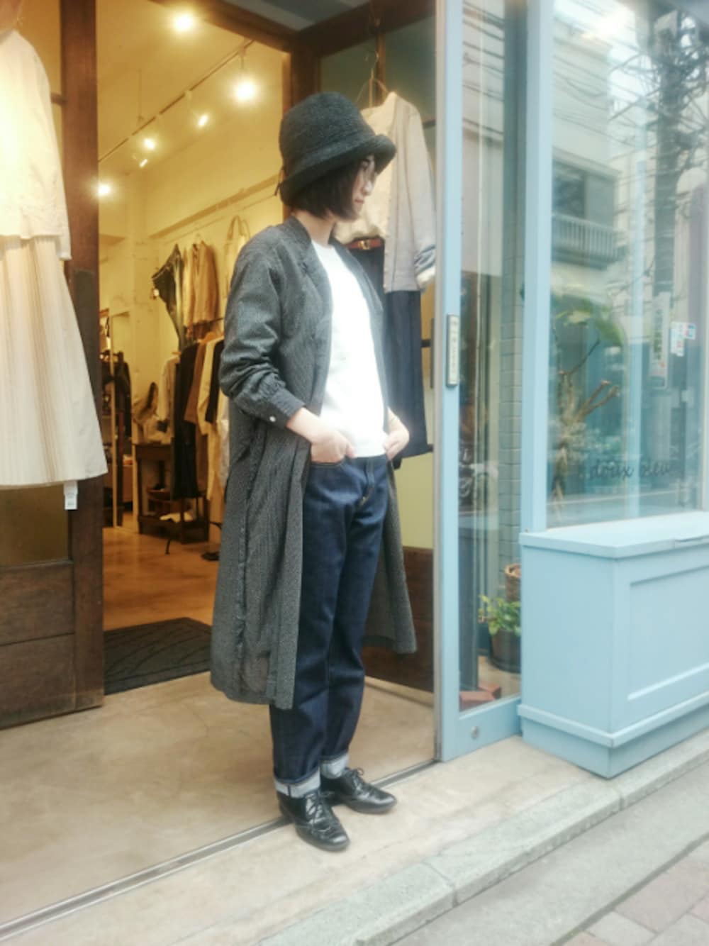 ブルー系のTシャツ/カットソー、ブルー系のデニムパンツ、ブラック系のシャツワンピースを着用したレディースの春コーディネートの1枚目の写真