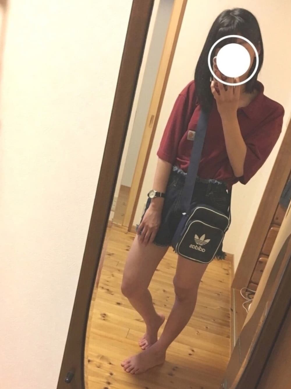 レッド系のポロシャツ、ブラック系のデニムパンツ、ブルー系のショルダーバッグを着用したレディースの夏コーディネートの1枚目の写真