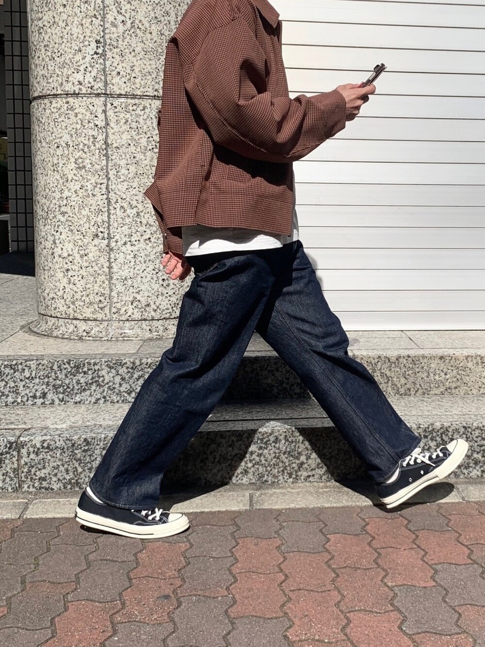 ブラウン系のブルゾン、ホワイト系のTシャツ/カットソー、ブルー系のデニムパンツを着用したメンズの春コーディネートの1枚目の写真