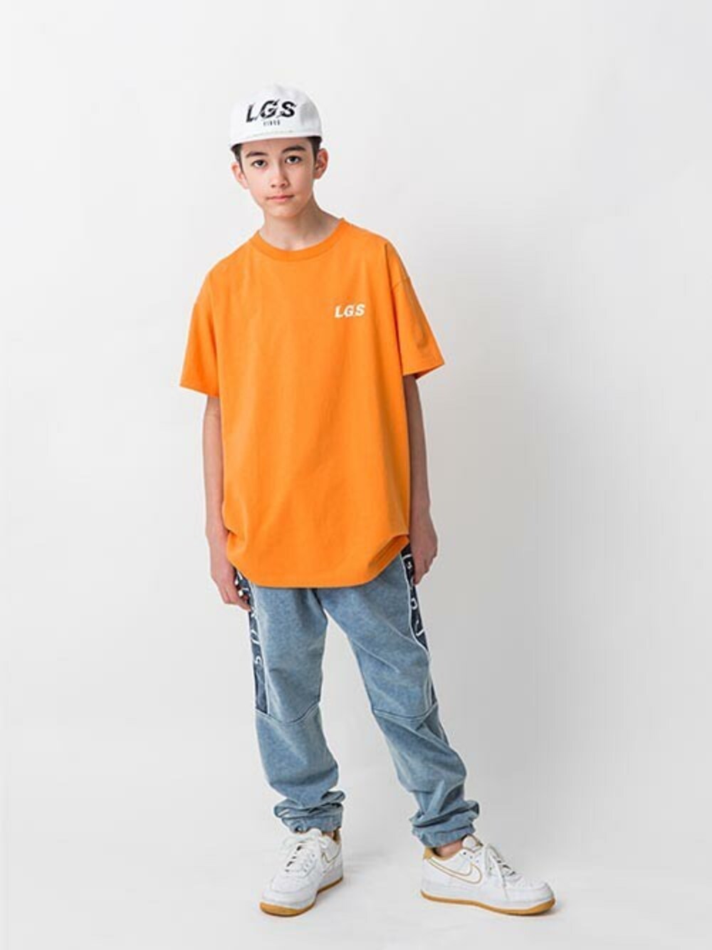 オレンジ系のTシャツ/カットソー、ブルー系のその他パンツ、ホワイト系のキャップを着用したキッズの春コーディネートの1枚目の写真