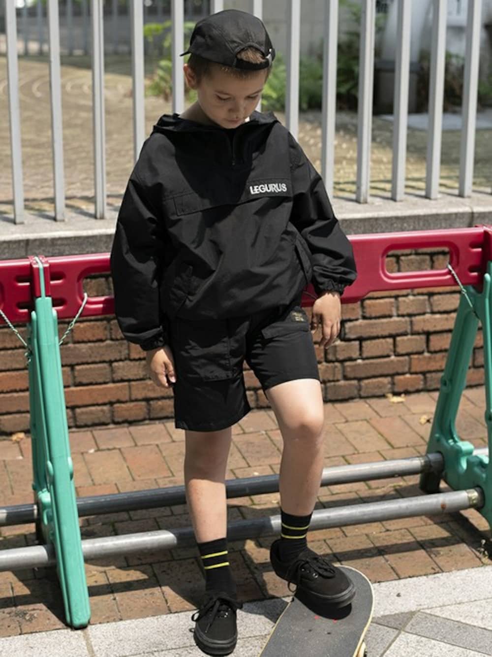 ブラック系のナイロンジャケット、ブラック系のその他パンツ、ブラック系のキャップを着用したキッズの夏コーディネートの1枚目の写真