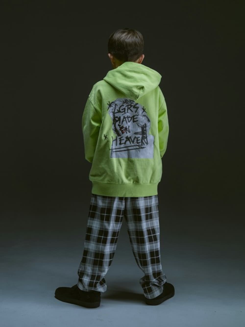 イエロー系のパーカー、ブラック系のその他パンツを着用したキッズの冬コーディネートの1枚目の写真