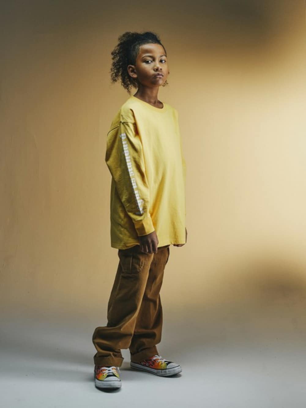 オレンジ系のTシャツ/カットソー、イエロー系のその他パンツを着用したキッズの冬コーディネートの1枚目の写真