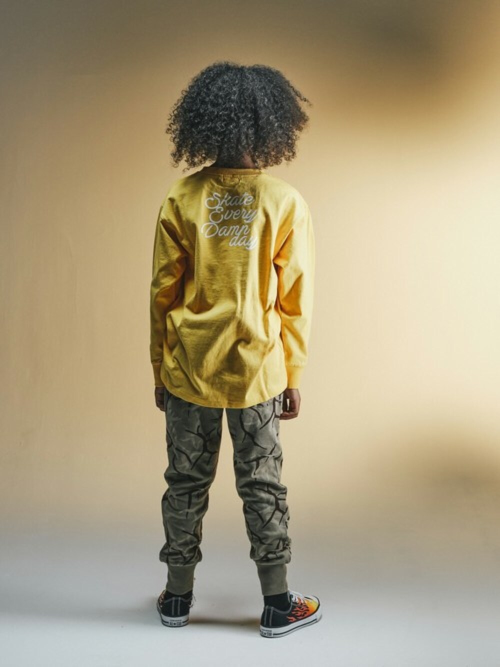 オレンジ系のTシャツ/カットソー、イエロー系のその他パンツを着用したキッズの冬コーディネートの1枚目の写真