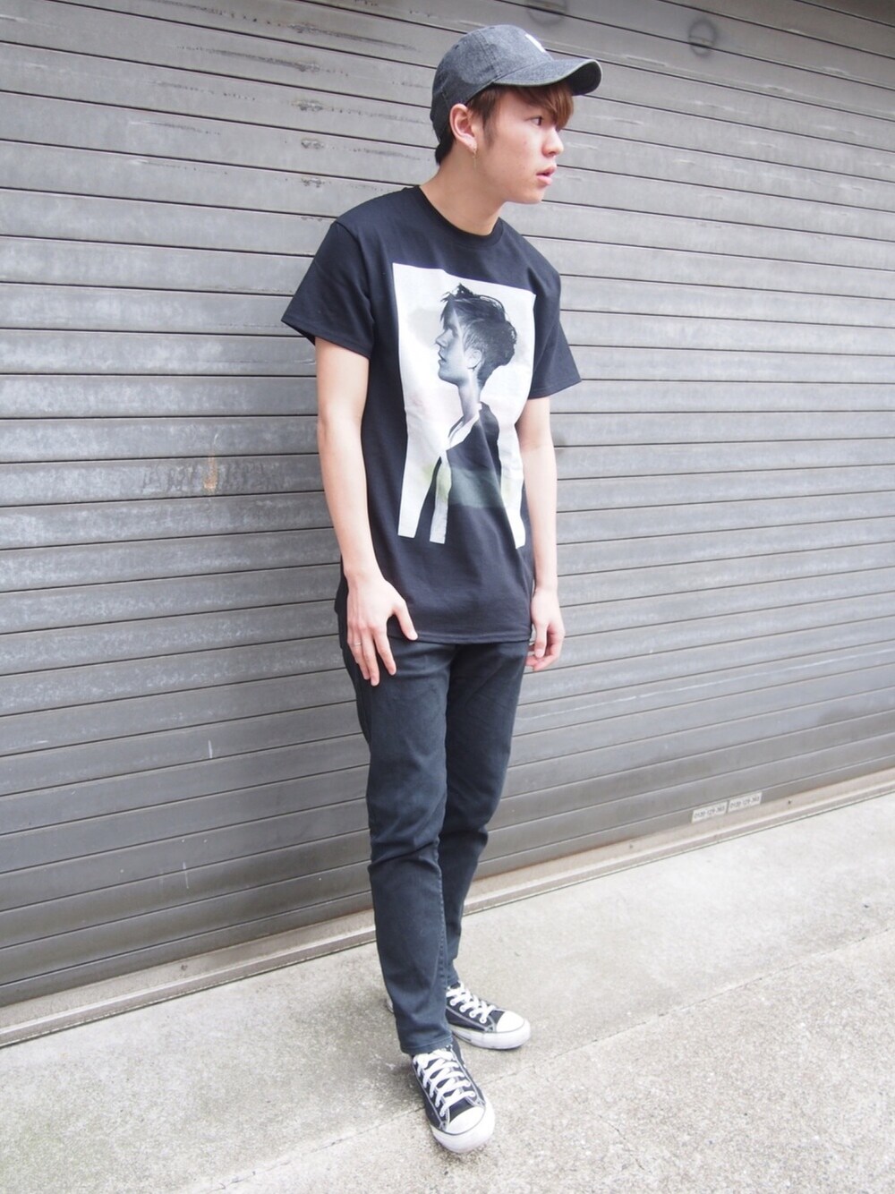 ブラック系のTシャツ/カットソー、ブラック系のスニーカー、ブラック系のデニムパンツを着用したメンズの春コーディネートの1枚目の写真