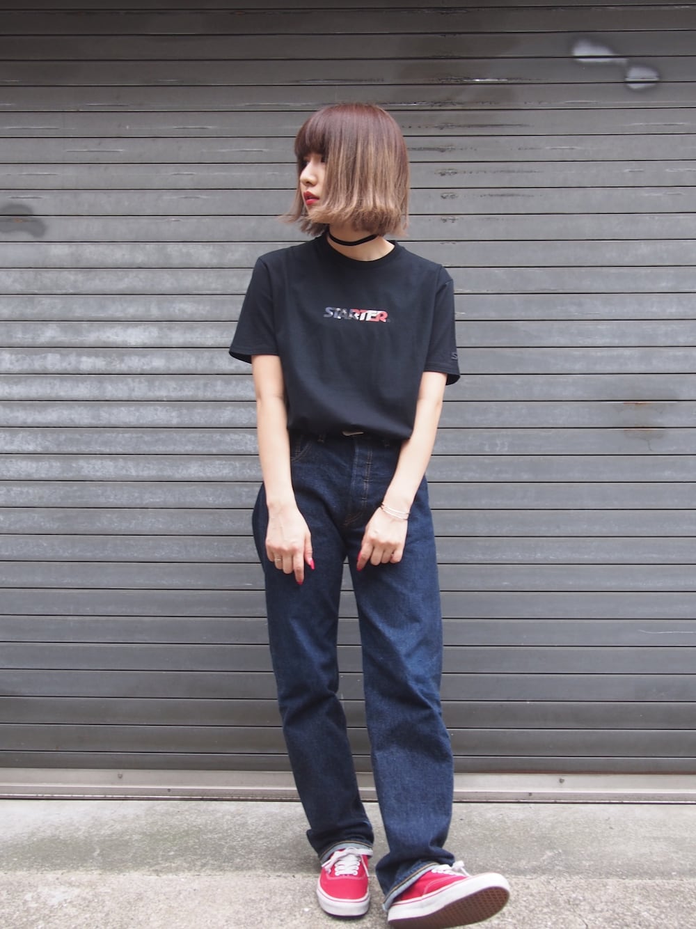 ブラック系のTシャツ/カットソー、ブルー系のデニムパンツ、レッド系のスニーカーを着用したレディースの春コーディネートの1枚目の写真