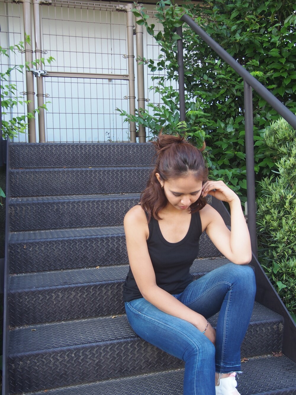 ブラック系のタンクトップを着用したレディースの夏コーディネートの1枚目の写真