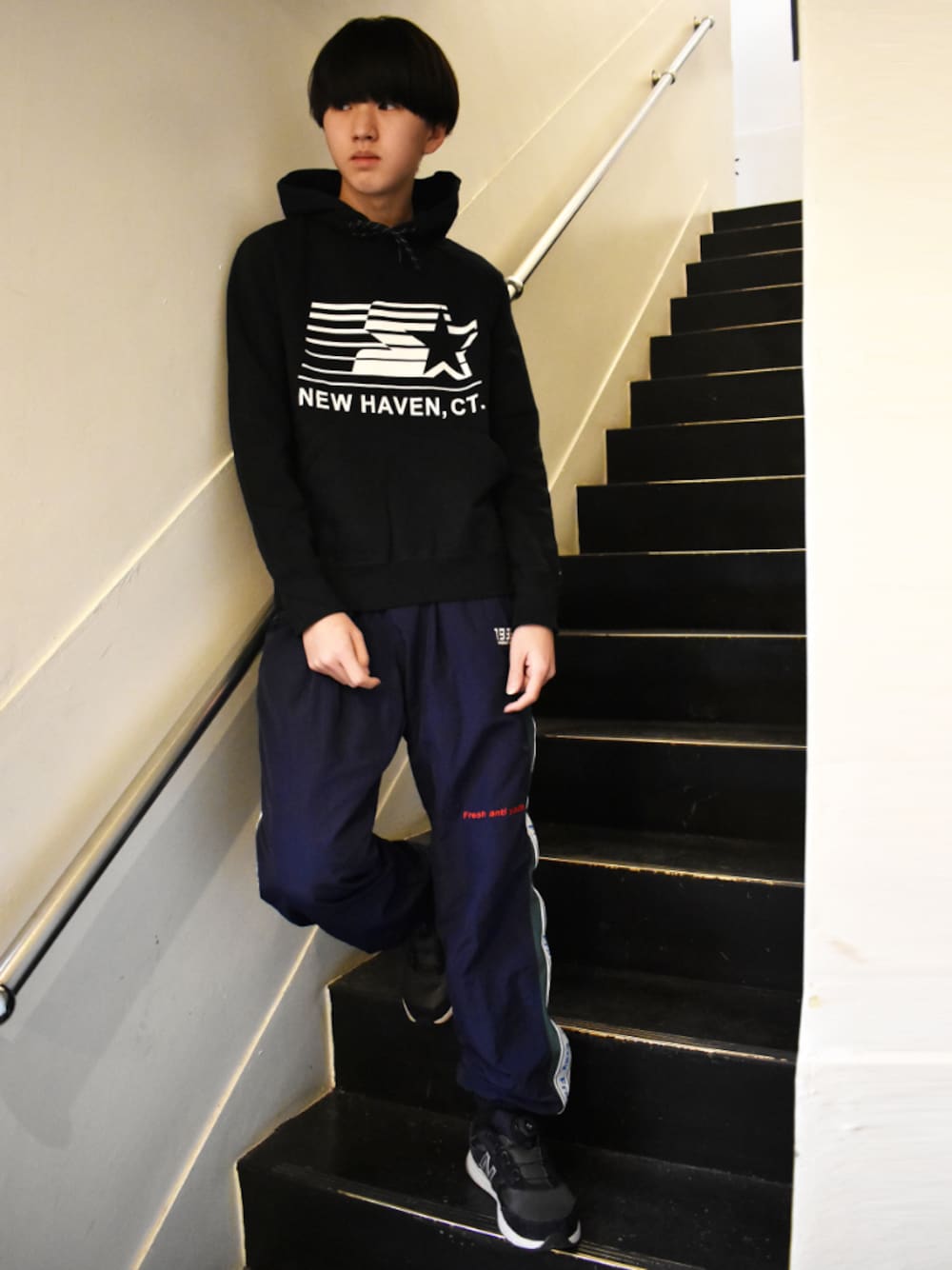 ブラック系のパーカー、ブルー系のパンツ、ブルー系のスニーカーを着用したメンズの冬コーディネートの1枚目の写真