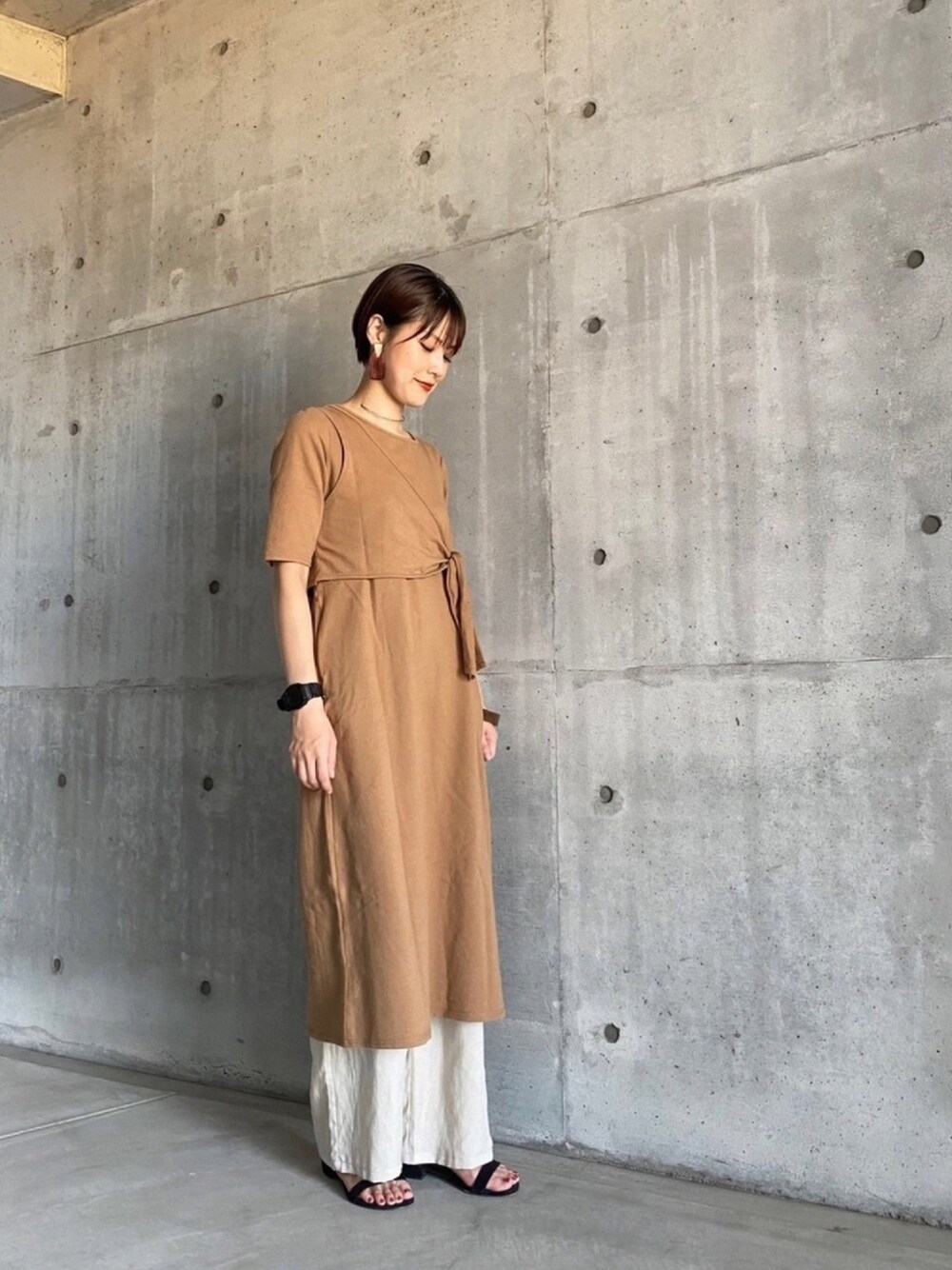 ベージュ系のワンピース、グレー系のその他パンツ、ブラック系のサンダルを着用したレディースの秋コーディネートの1枚目の写真