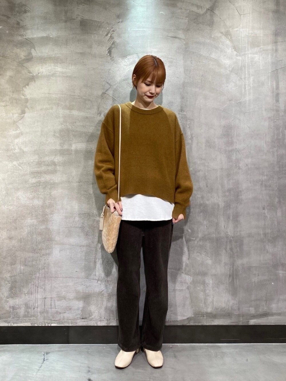 イエロー系のニット/セーター、ホワイト系のTシャツ/カットソー、ブラウン系のその他パンツを着用したレディースの冬コーディネートの1枚目の写真