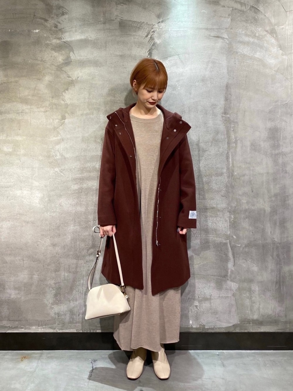 レッド系のその他アウター、グレー系のワンピース、ホワイト系のショルダーバッグを着用したレディースの冬コーディネートの1枚目の写真