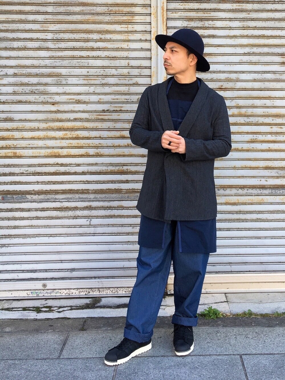 ブラック系のその他アウター、ブルー系のパンツ、ブラック系のスニーカーを着用したメンズの春コーディネートの1枚目の写真