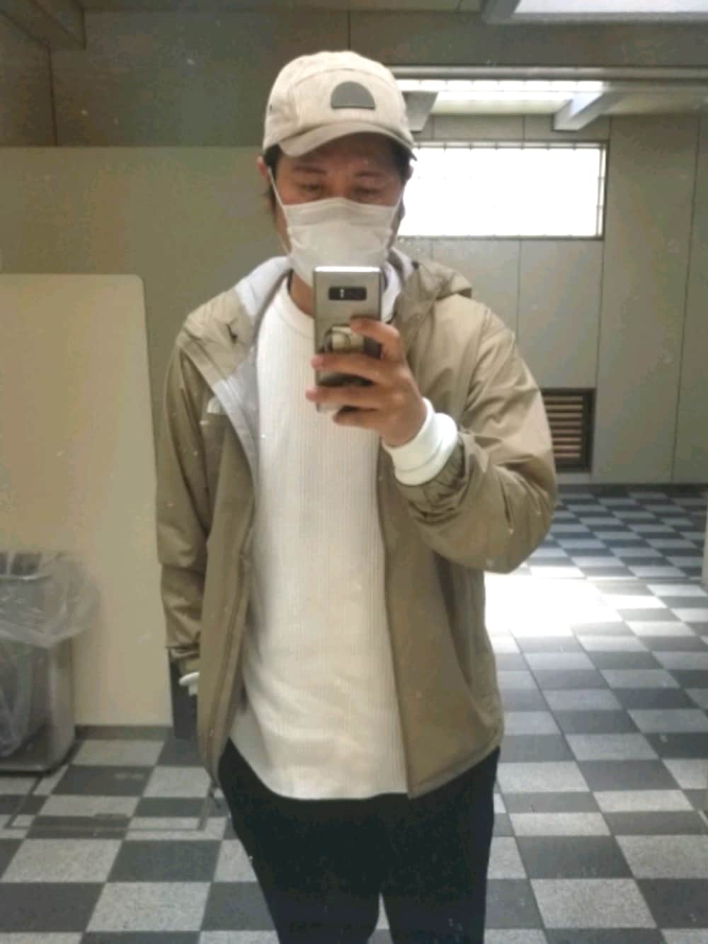 ベージュ系のマウンテンパーカーを着用したメンズの春コーディネートの1枚目の写真