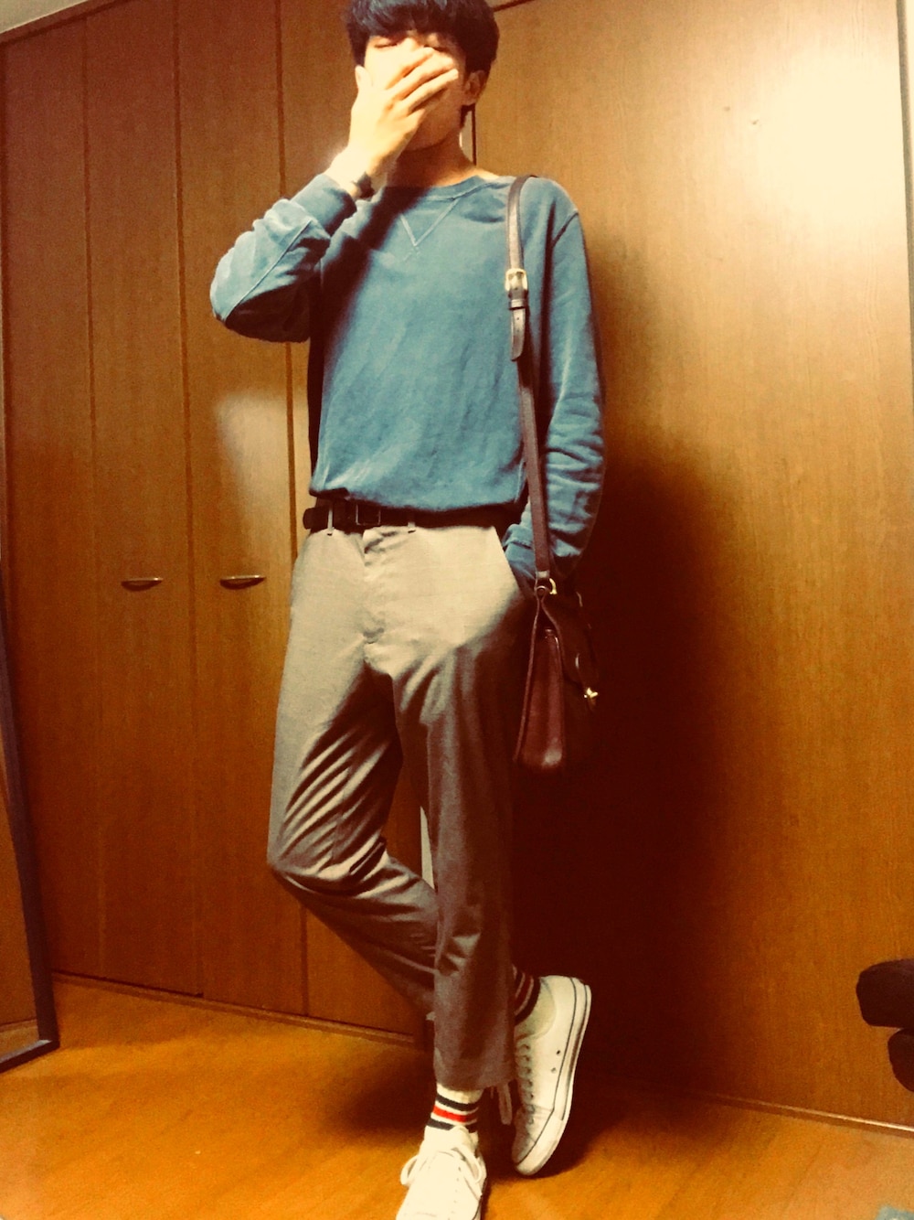 グレー系のスウェット、ブラウン系のショルダーバッグ、ブラウン系のパンツを着用したメンズの秋コーディネートの1枚目の写真