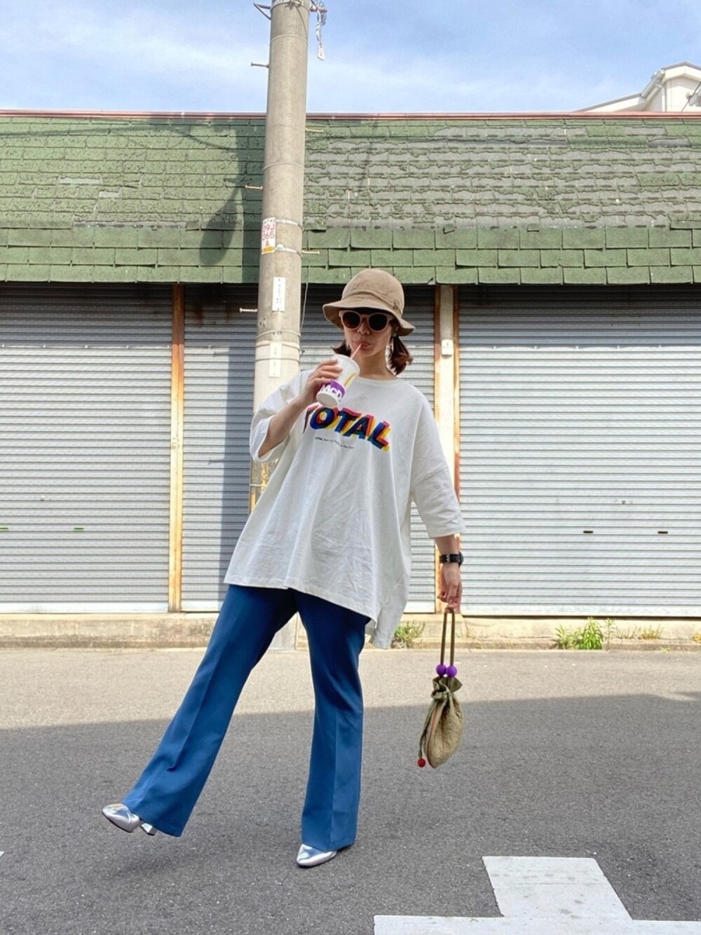 ホワイト系のTシャツ/カットソー、ブルー系のスラックス、シルバー系のパンプスを着用したレディースの春コーディネートの1枚目の写真