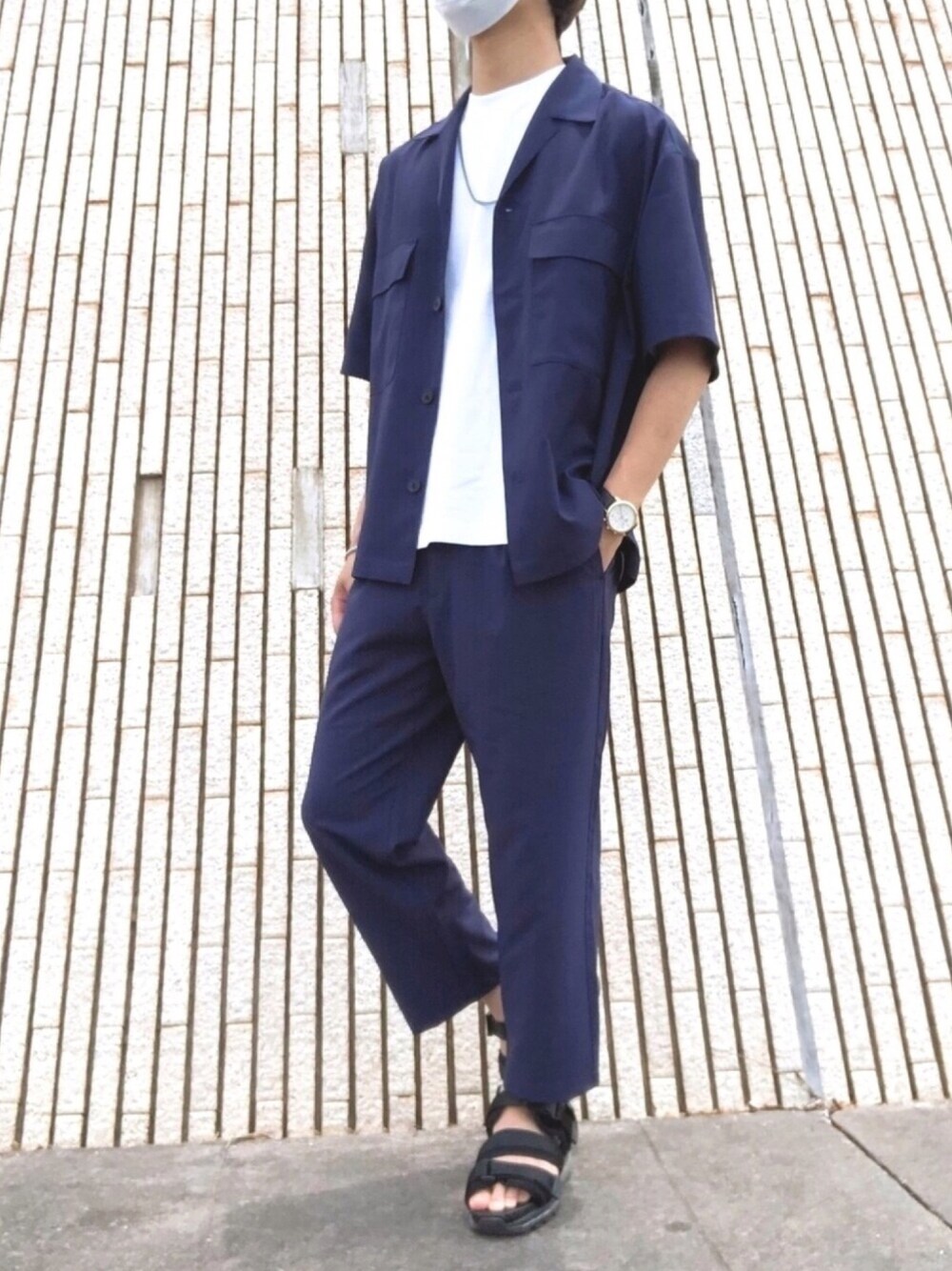 ブラック系のサンダル、ブルー系のスラックス、ホワイト系のTシャツ/カットソーを着用したメンズの夏コーディネートの1枚目の写真