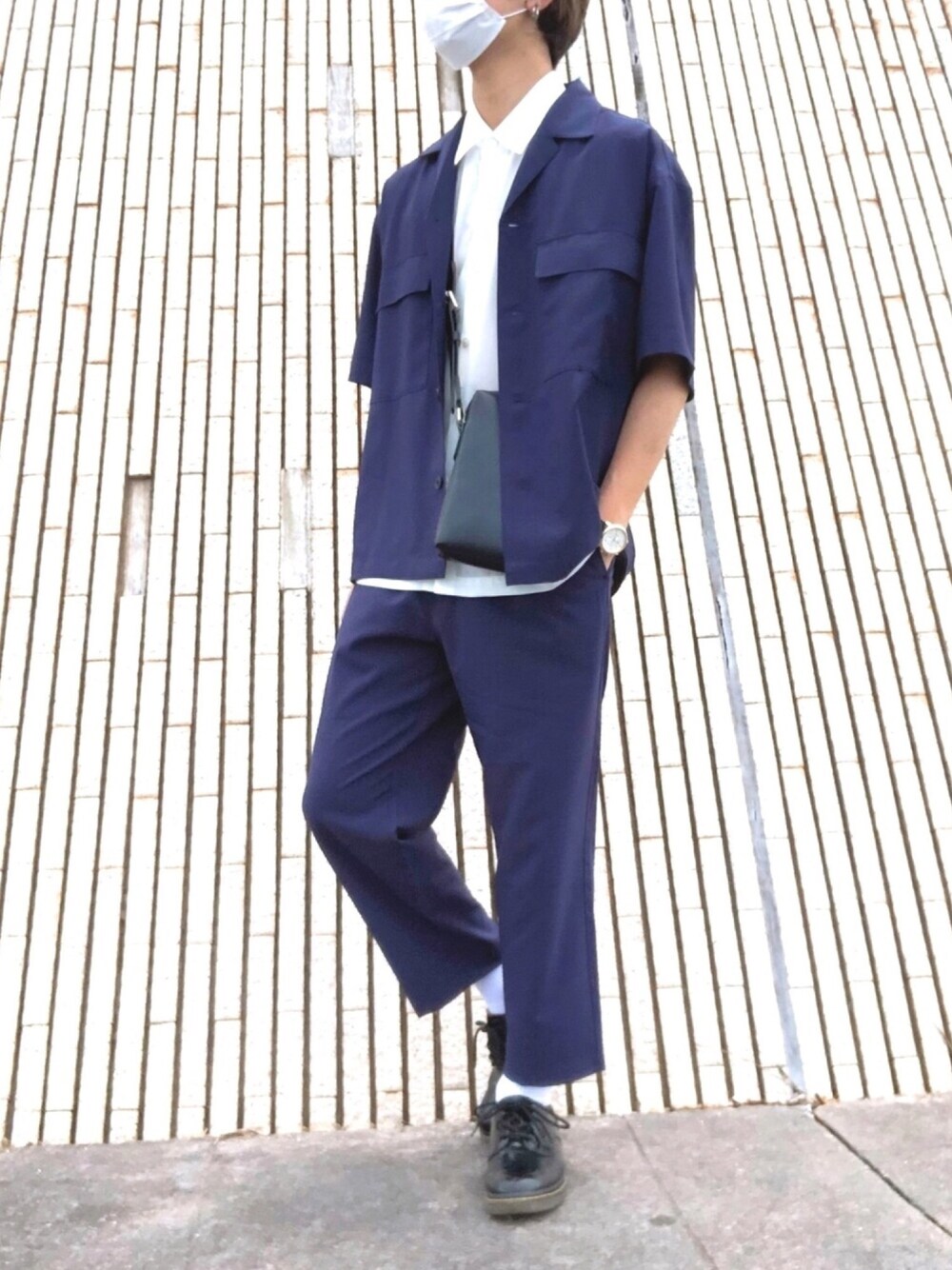 ブラック系のドレスシューズ、ブルー系のスラックス、ブラック系のショルダーバッグを着用したメンズの夏コーディネートの1枚目の写真