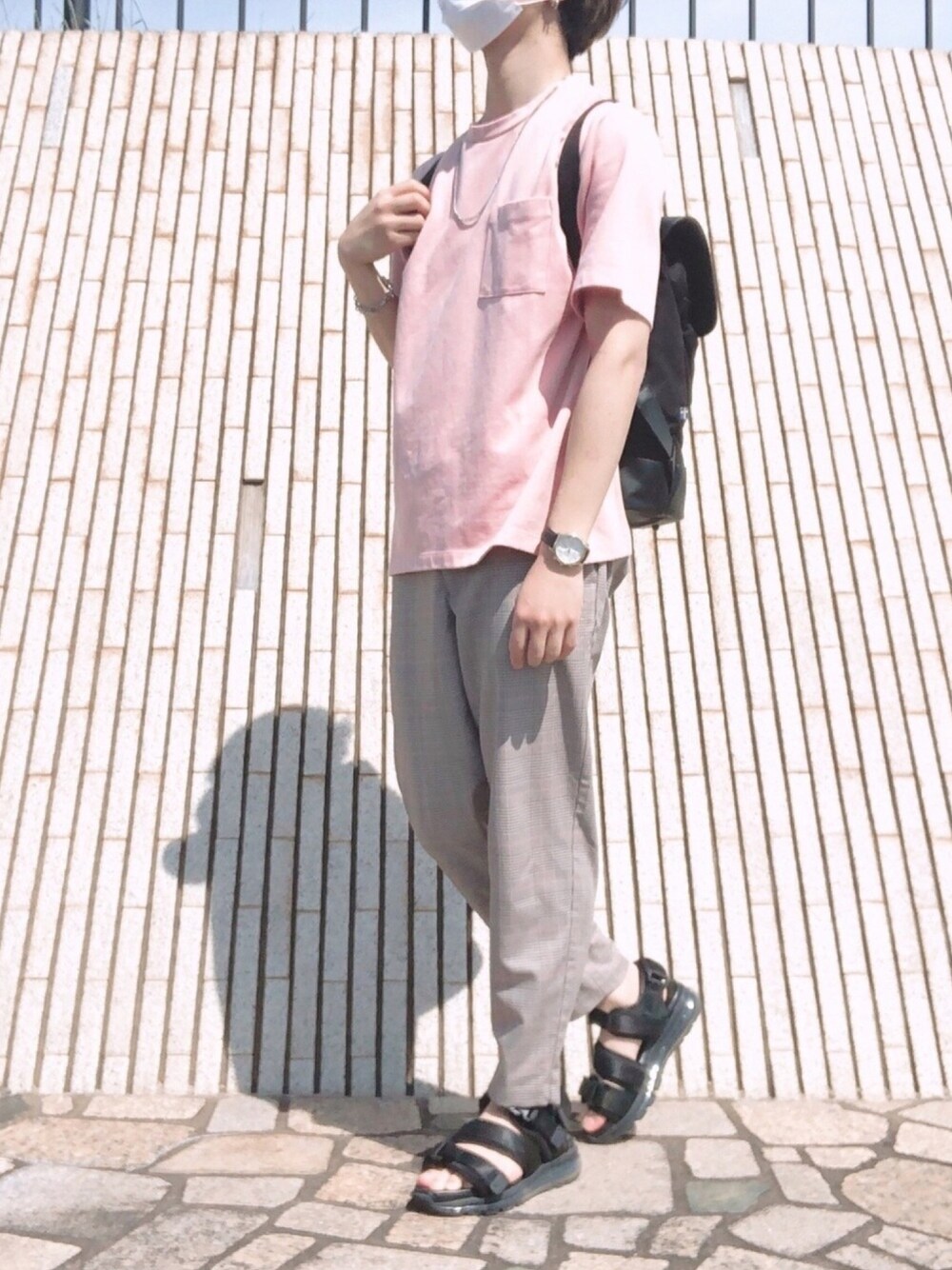 ブラック系のサンダル、ベージュ系のパンツ、ブラック系のバックパック/リュックを着用したメンズの夏コーディネートの1枚目の写真