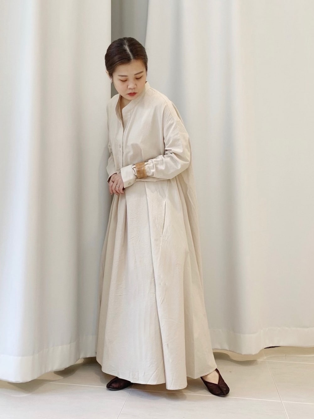 ベージュ系のワンピース、ブラウン系のバレエシューズ、ベージュ系のバングル/リストバンドを着用したレディースの夏コーディネートの1枚目の写真