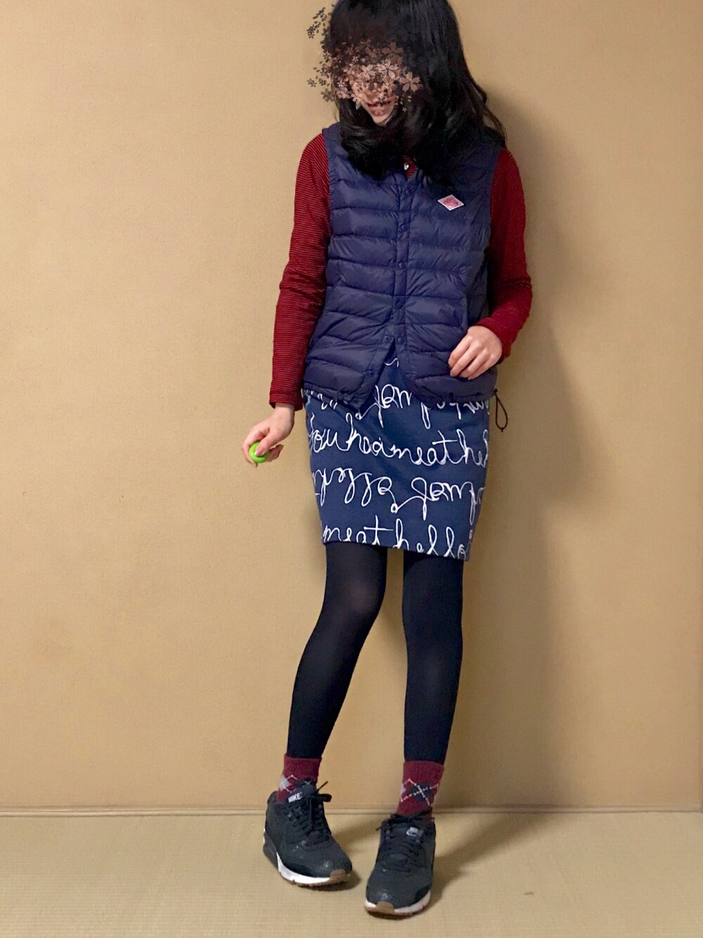 ブルー系のスカート、ブルー系のダウンベスト、レッド系のTシャツ/カットソーを着用したレディースの冬コーディネートの1枚目の写真