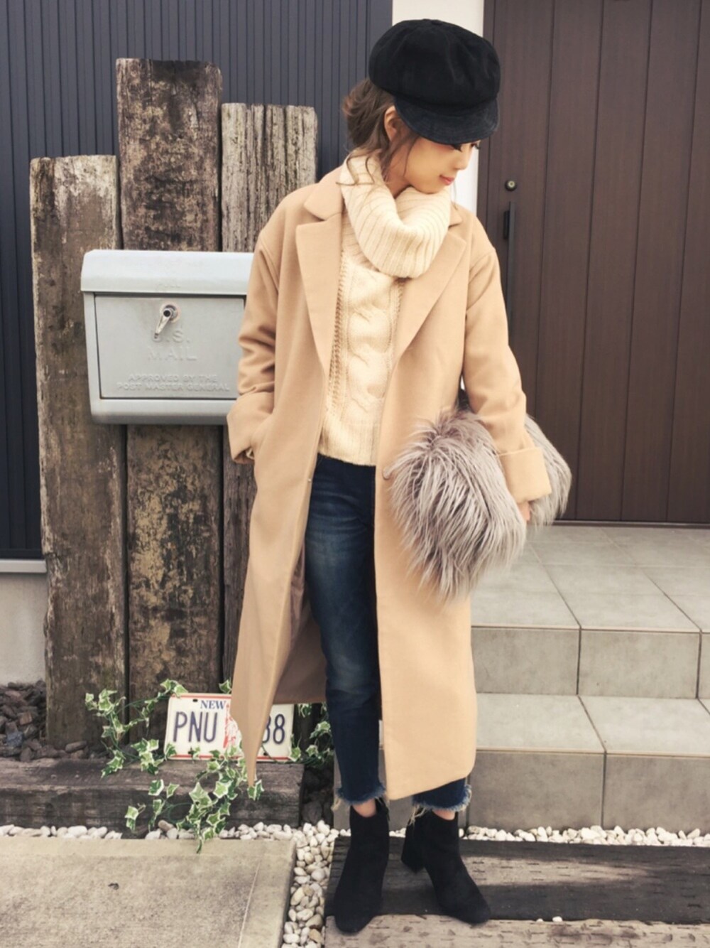 ベージュ系のニット/セーター、ベージュ系のチェスターコート、ブルー系のデニムパンツを着用したレディースの冬コーディネートの1枚目の写真