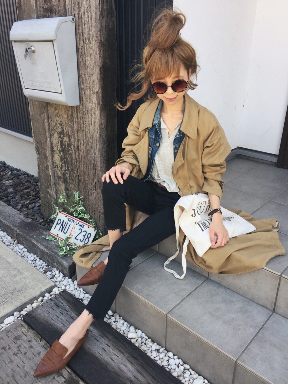 ブルー系のデニムジャケット、イエロー系のトレンチコート、グレー系のTシャツ/カットソーを着用したレディースの春コーディネートの1枚目の写真