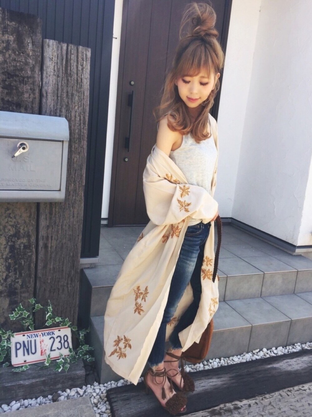 ベージュ系のシャツ/ブラウス、グレー系のタンクトップ、ブルー系のデニムパンツを着用したレディースの春コーディネートの1枚目の写真