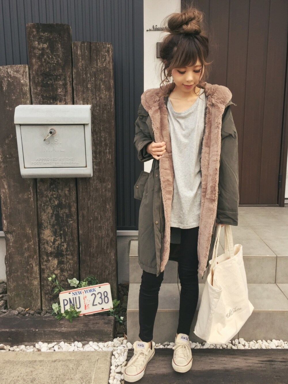 グリーン系のモッズコート、グレー系のTシャツ/カットソー、ブラック系のパンツを着用したレディースの秋コーディネートの1枚目の写真
