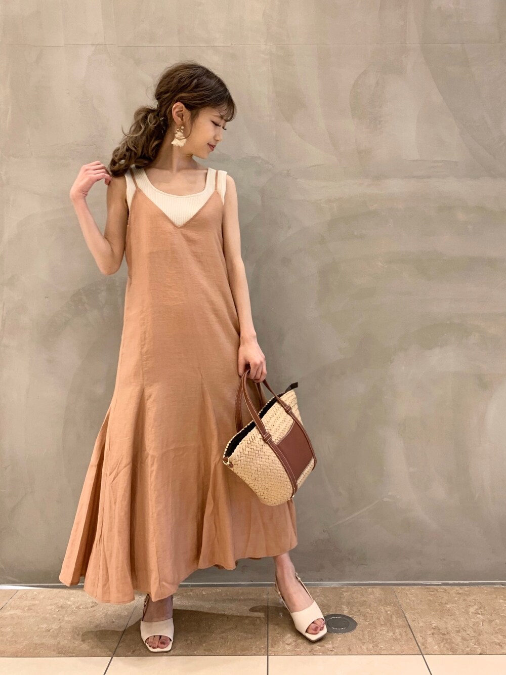 ブラウン系のトートバッグを着用したレディースの春コーディネートの1枚目の写真