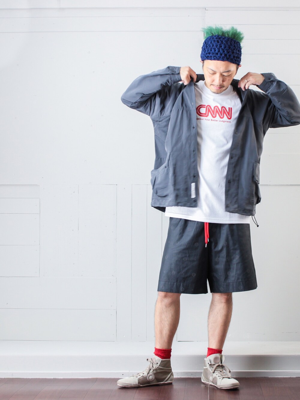 グレー系のナイロンジャケット、ホワイト系のTシャツ/カットソー、ブラック系のパンツを着用したメンズの秋コーディネートの1枚目の写真