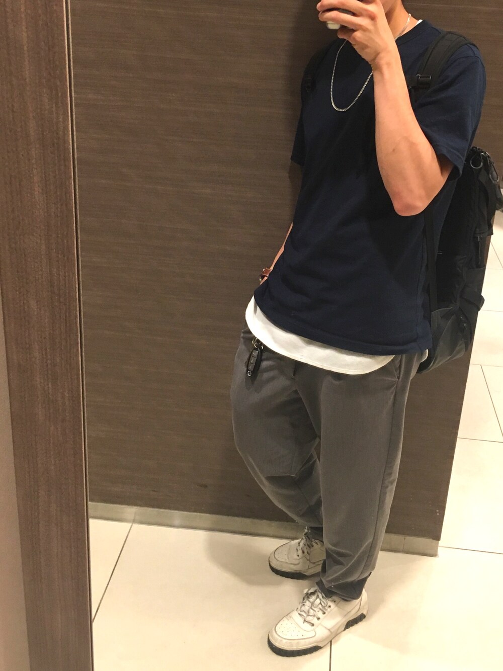 ホワイト系のタンクトップ、ブルー系のTシャツ/カットソー、グレー系のスラックスを着用したメンズの夏コーディネートの1枚目の写真