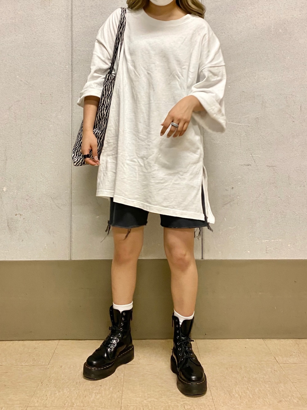 ホワイト系のTシャツ/カットソー、ブラック系のブーツを着用したレディースの夏コーディネートの1枚目の写真