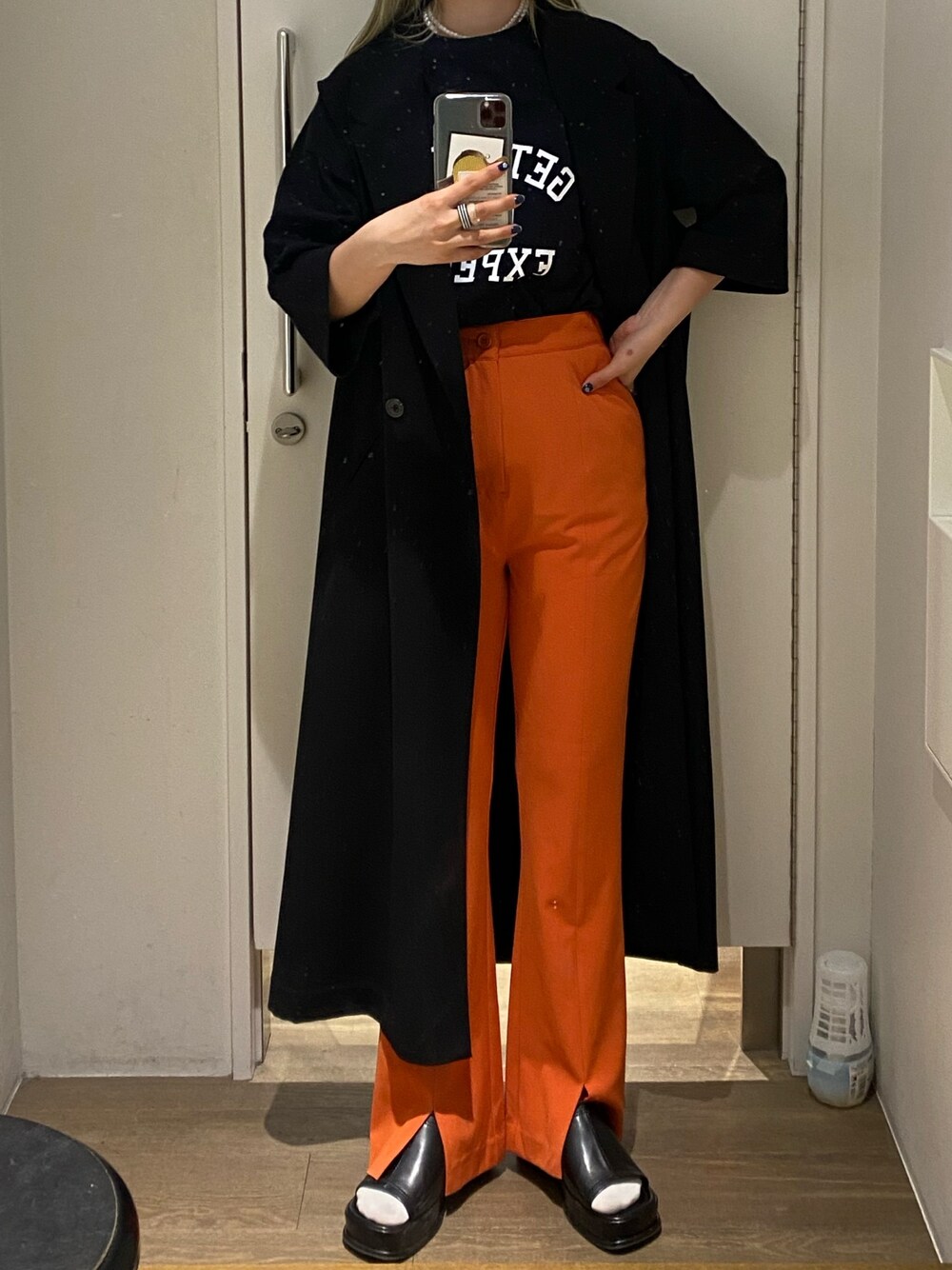 「主役はカラーパンツ、JEANASiS、ジーナシス、レイヤードスタイル、ロングベスト、フレアパンツ、ロゴT、カラーパンツ、オレンジ、春」｜「JEANASISのフットボールロゴTEE/948796（Tシャツ/カットソー、ブラック系）」を使った、ミサ(JEANASiS)さん（レディース・155cm）の春コーディネートの1枚目の写真