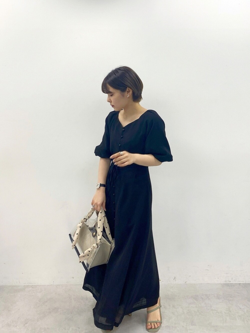 ブラック系のワンピース、その他のトートバッグ、シルバー系のアナログ腕時計を着用したレディースの春コーディネートの1枚目の写真