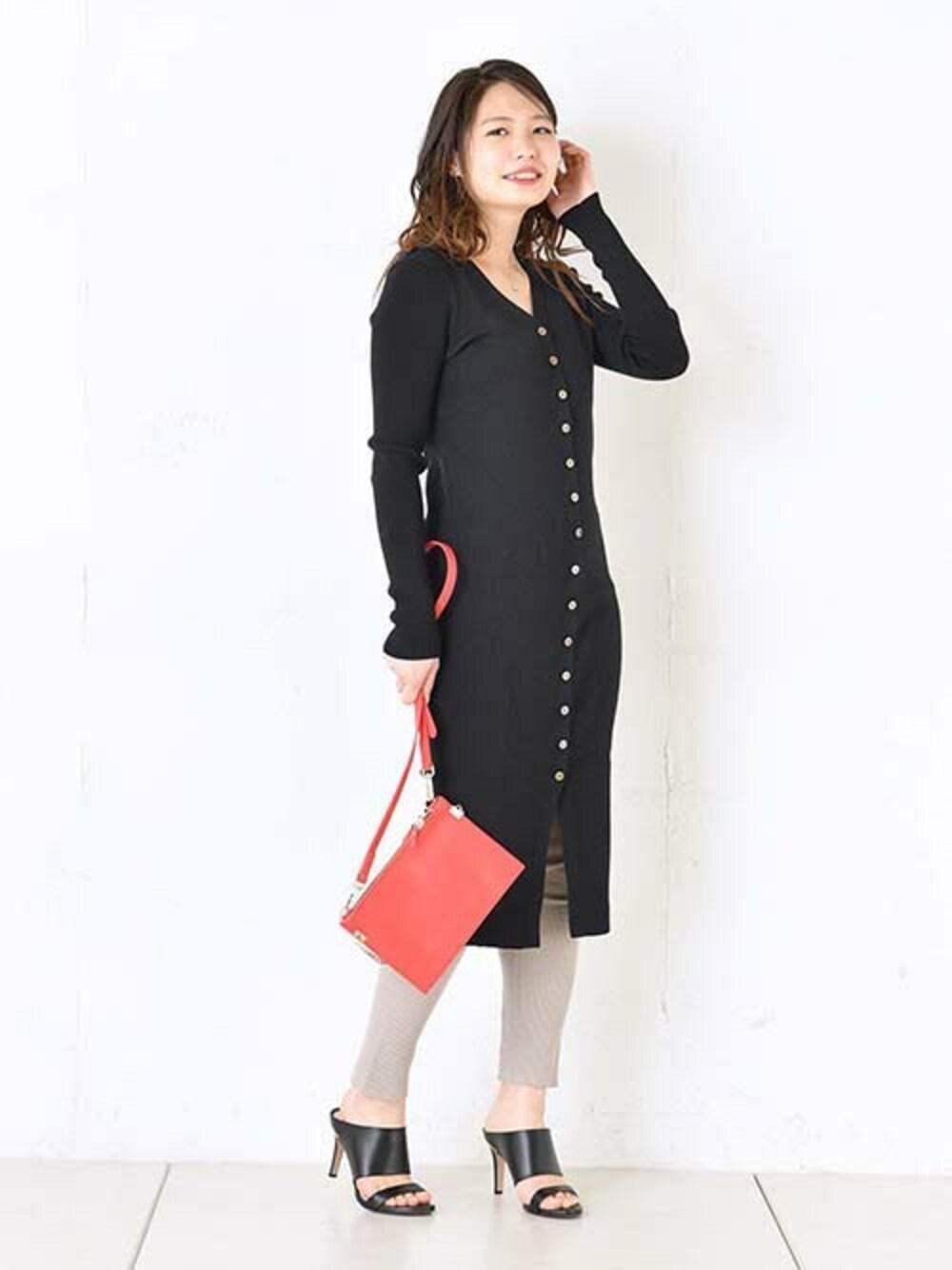 ブラック系のカーディガン/ボレロ、レッド系のショルダーバッグ、ベージュ系のレギンス/スパッツを着用したレディースの冬コーディネートの1枚目の写真