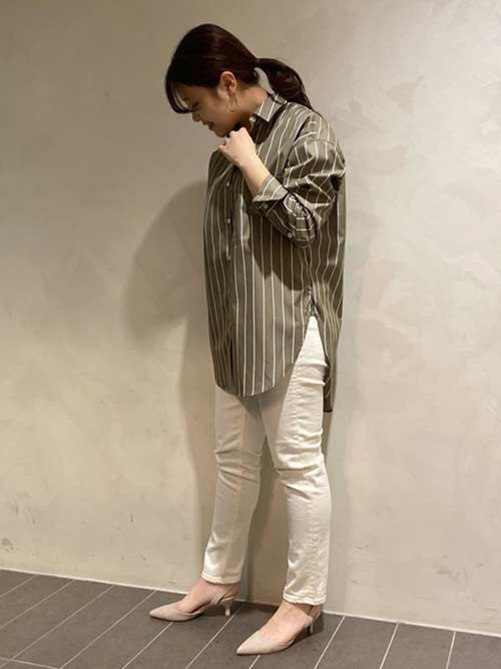 ホワイト系のデニムパンツ、グレー系のパンプス、グリーン系のシャツ/ブラウスを着用したレディースの春コーディネートの1枚目の写真