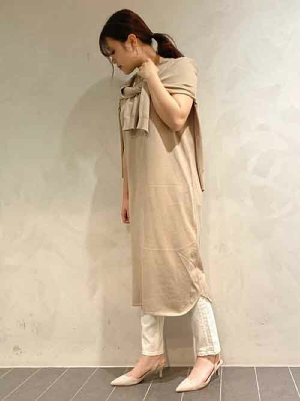 ベージュ系のワンピース、グレー系のパンプス、ホワイト系のデニムパンツを着用したレディースの春コーディネートの1枚目の写真