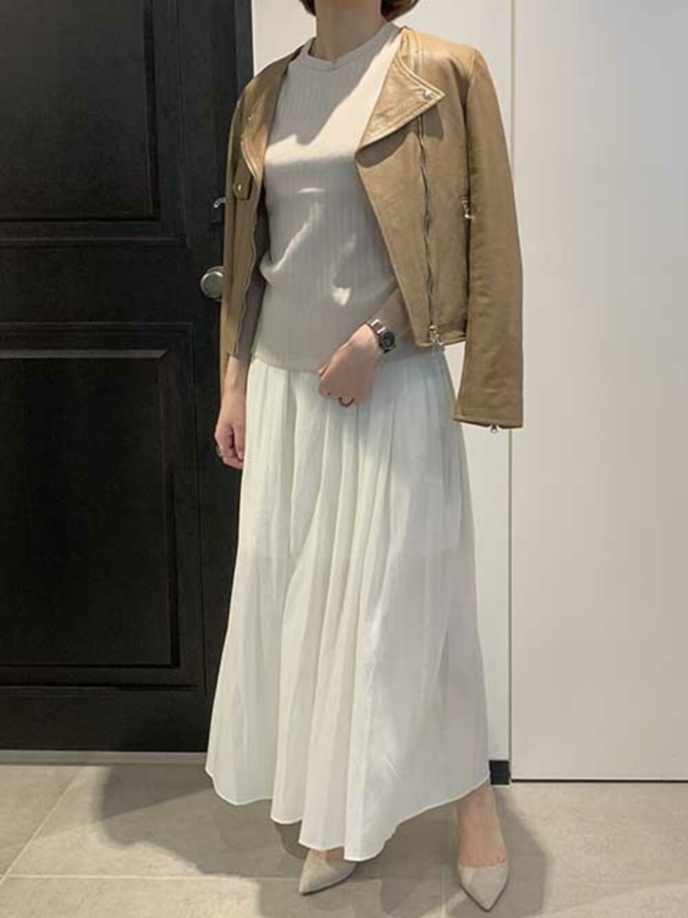 グレー系のパンプス、ベージュ系のライダースジャケット、ホワイト系のその他パンツを着用したレディースの春コーディネートの1枚目の写真