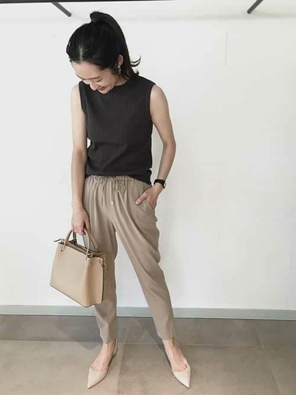 ベージュ系のハンドバッグ、ベージュ系のその他パンツ、ブラック系のタンクトップを着用したレディースの春コーディネートの1枚目の写真