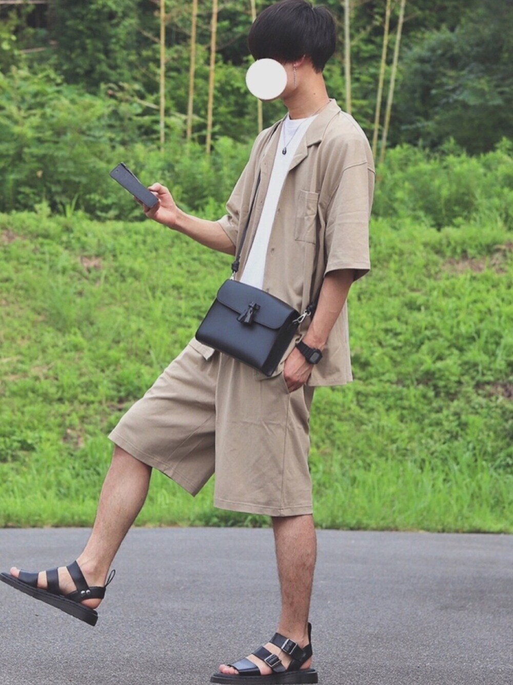 ベージュ系のセットアップ、ホワイト系のTシャツ/カットソー、ブラック系のサンダルを着用したメンズの夏コーディネートの1枚目の写真